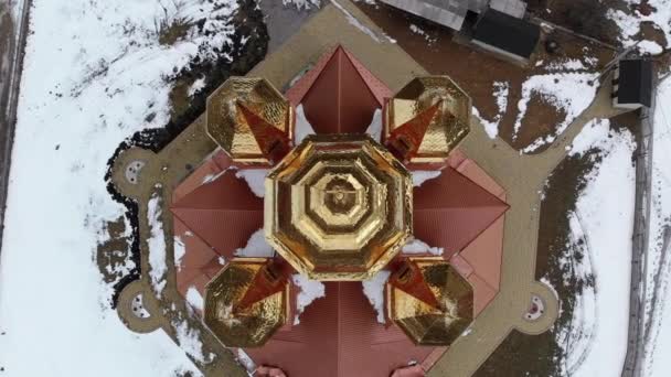 Letecký pohled na ukrajinský kostel se zlatými kopulemi v Karpatské vesnici v zimě