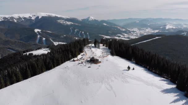 Pistas aéreas de esquí con esquiadores y remontes en la estación de esquí. Bosque nevado de montaña — Vídeos de Stock