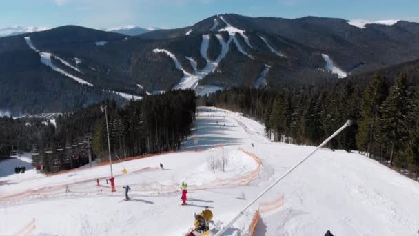 Uitzicht vanuit de lucht op de skiërs gaan skipistes in de buurt van skiliften op skigebied. Bukovel — Stockvideo