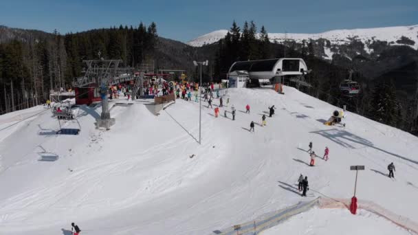 Aerial view Crowd of Skiers Skiing on Peak Ski Slope near Ski Lifts. Ski Resort — Wideo stockowe