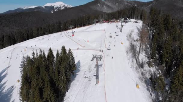 Inclinações aéreas de esqui com esquiadores e elevadores de esqui no Ski Resort. Floresta de montanha nevada — Vídeo de Stock