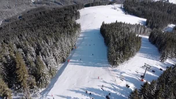 Skipisten mit Skifahrer und Skilifte auf Skigebiet. Verschneiter Bergwald