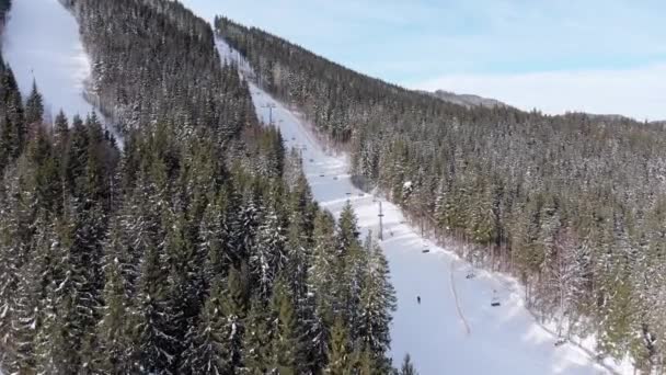 Veduta aerea degli sciatori scendere piste da sci vicino agli impianti di risalita sulla stazione sciistica. Bukovel — Video Stock