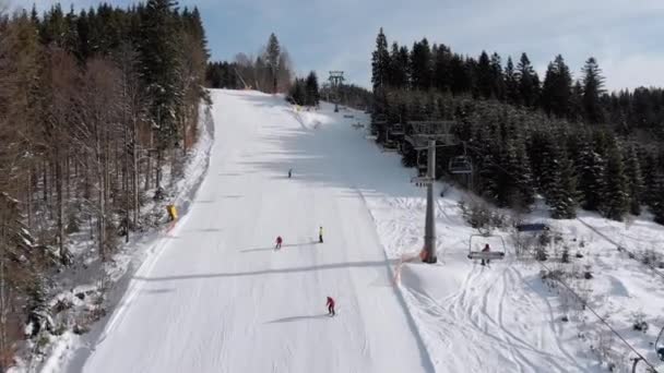 Aerial view of Skiers go Down Ski Slopes near Ski Lifts on Ski Resort. Bukovel — Stock Video