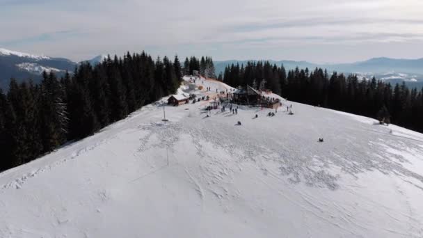 Letecké sjezdovky s lyžaři a vleky na lyžařském středisku. Sněžný horský les — Stock video