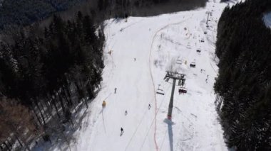 Aerial view of Ski Slopes with Skiers go Down under Ski Lifts on Ski Resort