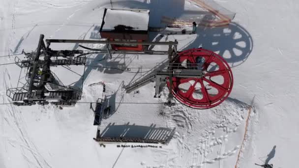 Vue aérienne du téléski pour les skieurs de transport sur la piste de ski enneigée. Drone survole le télésiège — Video