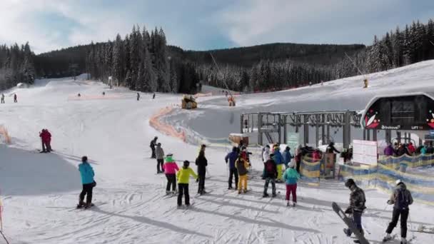 Vista aerea su molte persone che sciano sulle piste da sci vicino agli impianti di risalita sulla stazione sciistica — Video Stock