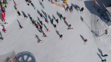 Aerial view Crowd of Skiers Skiing on Peak Ski Slope near Ski Lifts. Ski Resort