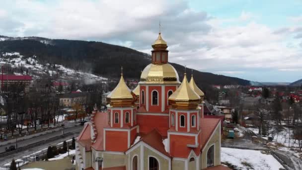LuchtDrone uitzicht op de Oekraïense kerk met gouden koepels in Karpaten dorp in de winter — Stockvideo