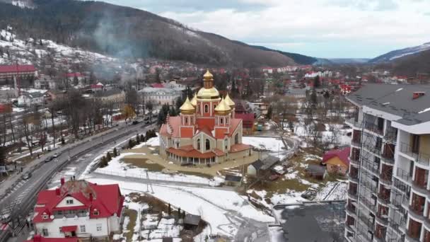 Luftaufnahme der ukrainischen Kirche mit goldenen Kuppeln im Karpatendorf im Winter — Stockvideo