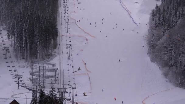 Лижники і сноубордисти їдуть на сніговому схилі на лижному курорті в сонячний день. — стокове відео