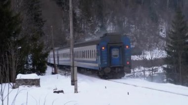 Old Train Rides on a Railway Crossing in the Countryside in Winter. Snow on the Ground.