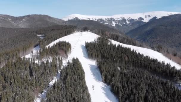 Pistas aéreas de esquí con esquiadores y remontes en la estación de esquí. Bosque nevado de montaña — Vídeos de Stock
