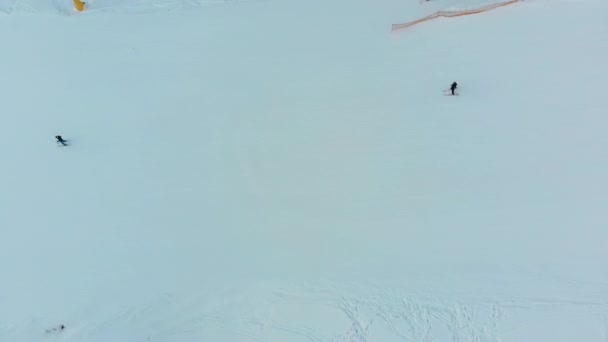 Top Luftaufnahme der Skifahrer Rutschen auf verschneiter Skipiste auf Skigebiet im Winter — Stockvideo