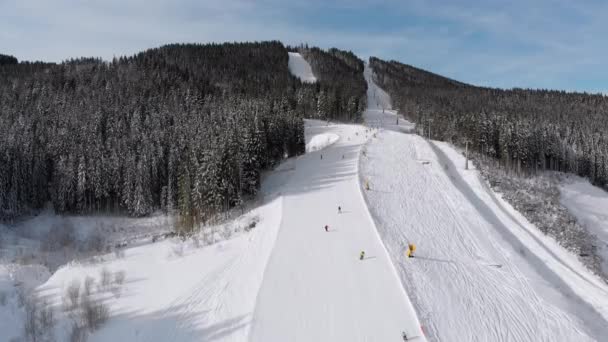 Aerial view Lot of Skiers go Down the Ski Slopes. Drone Flies Low Next to Skiers — Stock video