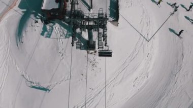 Aerial Top view of Ski Lift for Transportation Skiers on Snowy Ski Slope. Drone Flies over Chair Lift