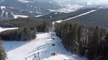 Aerial view of Ski Slopes with Skiers go Down under Ski Lifts on Ski Resort
