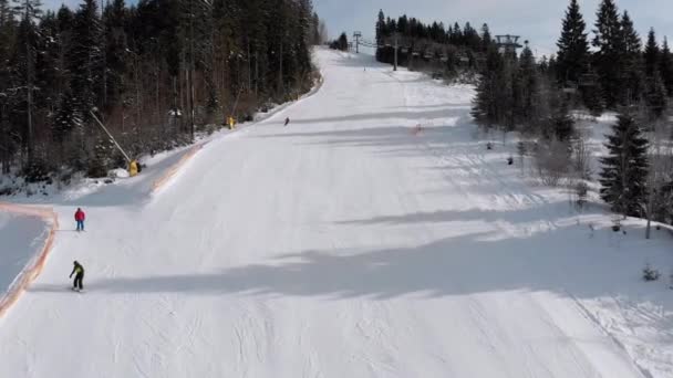 Aerial view of Skiers go Down Ski Slopes near Ski Lifts on Ski Resort. Bukovel — Stock Video