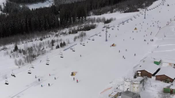 Widok z lotu ptaka na narciarzy w dół Stoki narciarskie w pobliżu wyciągów narciarskich w ośrodku narciarskim. Bukowel — Wideo stockowe