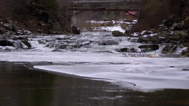 Rapid Flow of Water from a Mountain Creek and Stone Rapids with Snow in Winter. Waterfall. Slow Motion — Stock video