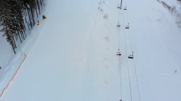 Uitzicht vanuit de lucht op skipistes met skiërs en skiliften op skigebied in de winter — Stockvideo