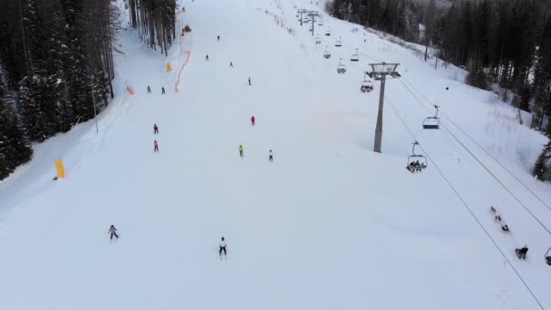 Vista aérea de las pistas de esquí con esquiadores y remontes en la estación de esquí en invierno — Vídeo de stock