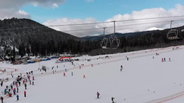 Vista aerea su molte persone che sciano sulle piste da sci vicino agli impianti di risalita sulla stazione sciistica — Video Stock
