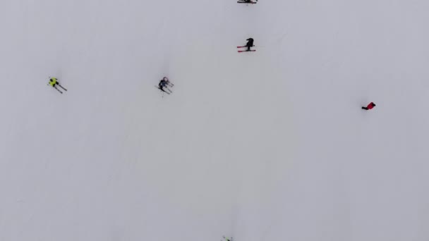 Aerial Top view of Skiers go Down the Ski Slope on Ski Resort in Mountains — Stock Video