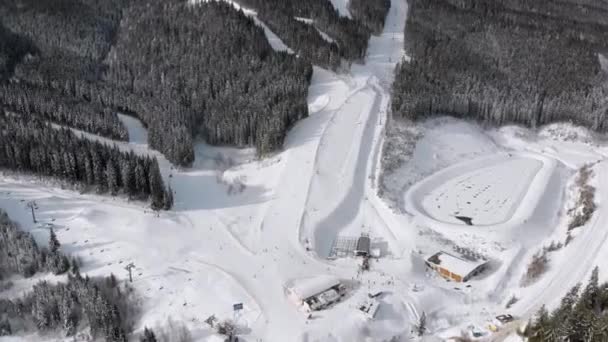 Aerial view of Skiers go Down Ski Slopes near Ski Lifts on Ski Resort. Bukovel — Stock Video