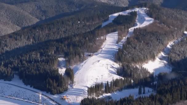 Skifahrer fahren in den Bergen auf einer verschneiten Piste in einem Skigebiet in Sunny Day — Stockvideo