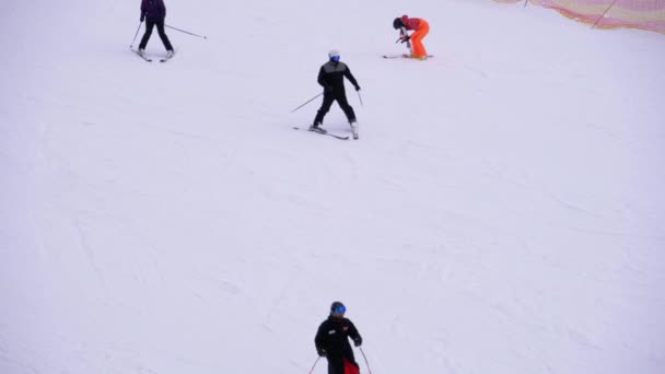 Les skieurs et les snowboarders montent sur une piste enneigée dans une station de ski — Video