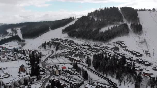 Vista aérea de la estación de esquí con pistas de esquí y esquiadores. Bosque de abeto nevado. Bukovel. — Vídeos de Stock
