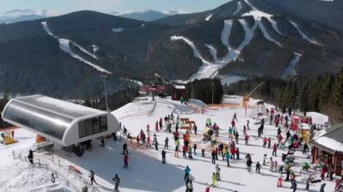 Aerial view Crowd of Skiers Skiing on Peak Ski Slope near Ski Lifts. Ski Resort