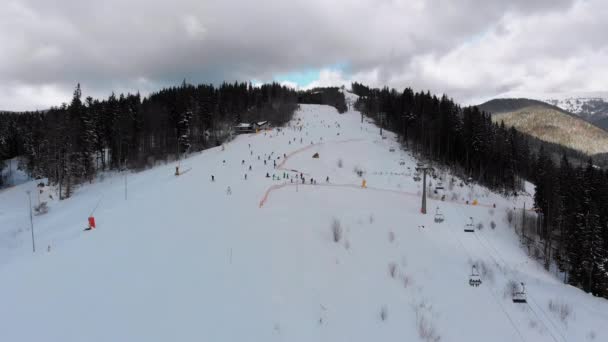 Vista aérea sobre pistas de esqui com esquiadores e elevadores de esqui no resort de esqui no inverno — Vídeo de Stock