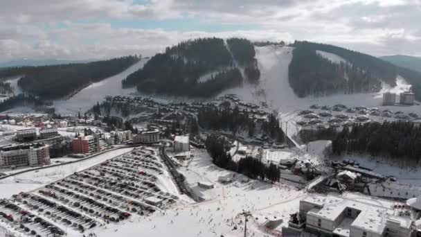 Vista aérea de la estación de esquí con pistas de esquí y esquiadores. Bosque de abeto nevado. Bukovel. — Vídeos de Stock