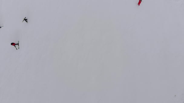 Aerial Top view of Skiers go down the Ski Slope on Ski Resort w Górach — Wideo stockowe