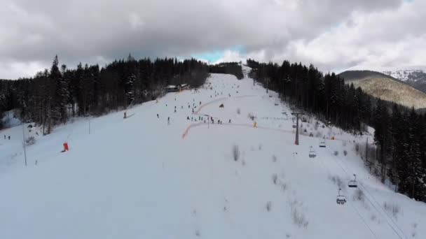 Vista aérea sobre pistas de esqui com esquiadores e elevadores de esqui no resort de esqui no inverno — Vídeo de Stock