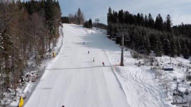 Kayakçıların kayak merkezindeki kayak asansörlerinin yakınındaki kayak pistlerinin havadan görünüşü. Bukovel