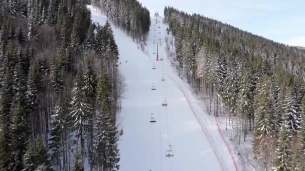 Uitzicht vanuit de lucht op de skiërs gaan skipistes in de buurt van skiliften op skigebied. Bukovel — Stockvideo