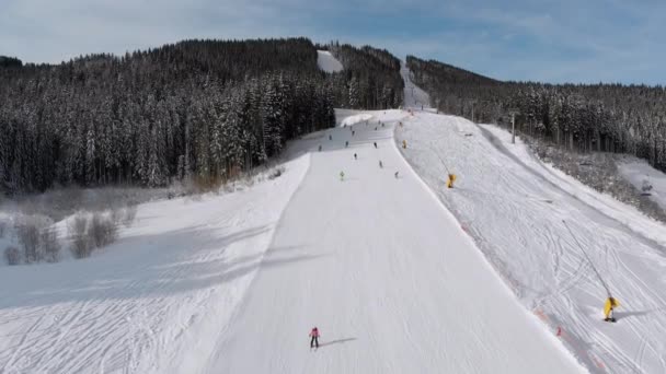 Aerial view Lot of Skiers go Down the Ski Slopes. Drone Flies Low Next to Skiers — Stock Video