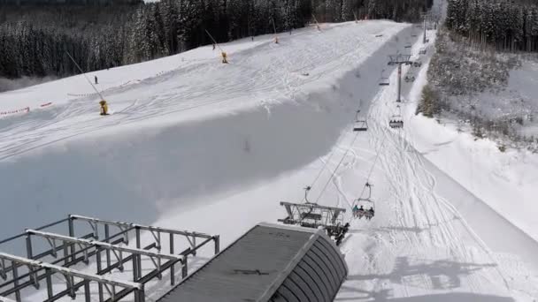 Aerial Top view of Ski Lift for Transportation Skiers on Snowy Ski Slope. Drone Flies over Chair Lift — ストック動画