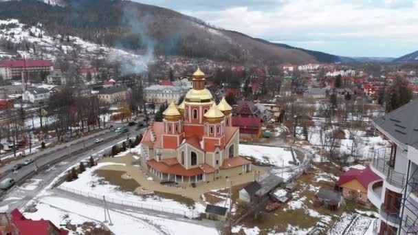Widok z lotu ptaka ukraińskiego kościoła ze złotymi kopułami w Karpatach Village w zimie — Wideo stockowe