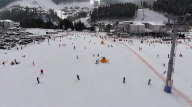 Aerial view on Lot of People Skiing on Ski Slopes near Ski Lifts on Ski Resort