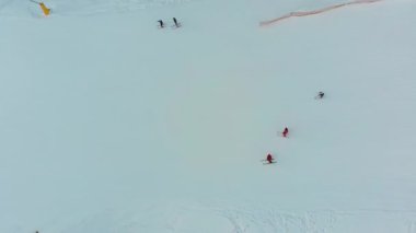 Kayakçıların en iyi hava manzarası, kışın kayak merkezinde karlı kayak yamacında kayıyor.