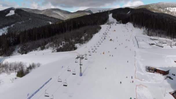 Aerial Stoki narciarskie z narciarzami i wyciągami narciarskimi w ośrodku narciarskim Snowy Mountains — Wideo stockowe