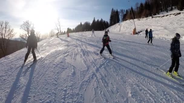 First-person zicht op amateur-skiërs glijden naar beneden op de skipiste bij skigebied — Stockvideo