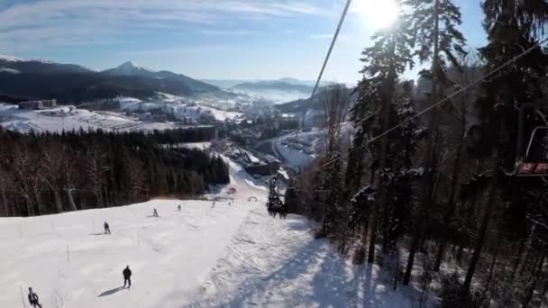 Pov från skidstolslyft till snöig skidbacke, skidåkare glider på skidbacke. — Stockvideo