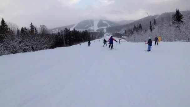 Vista en primera persona de los esquiadores aficionados y snowboarders que se deslizan por la pista de esquí en la estación de esquí — Vídeos de Stock
