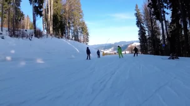Катание на лыжах по горнолыжному склону на горнолыжном курорте. Люди катаются на лыжах по склону — стоковое видео